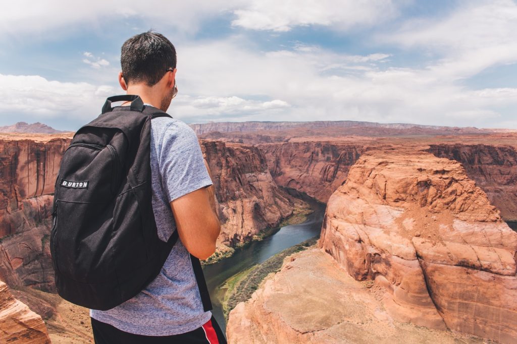 randonneur avec sac à dos observant le Grand Canyon et ses falaises rocheuses