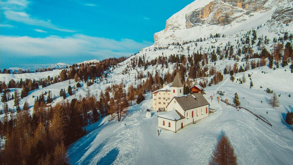 église de montagne enneigée dans les dolomites d'alta badia en italie