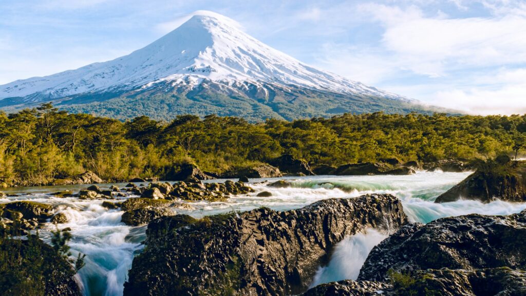 volcan Osorno enneigé dominant forêt verte et rivière blanche, Chili