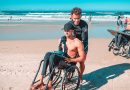 man in black shorts sitting on black wheelchair on beach during daytime