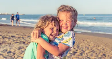 Vacances en famille pas cher en août 2026 en France girl in white blue and green floral dress on beach during daytime