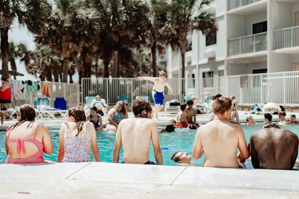 A group of people sitting next to a swimming pool