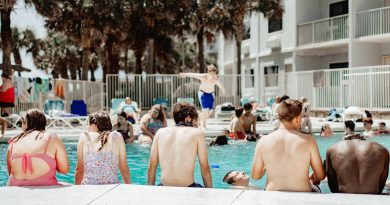A group of people sitting next to a swimming pool