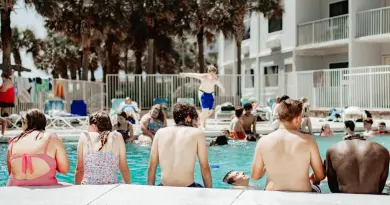 A group of people sitting next to a swimming pool