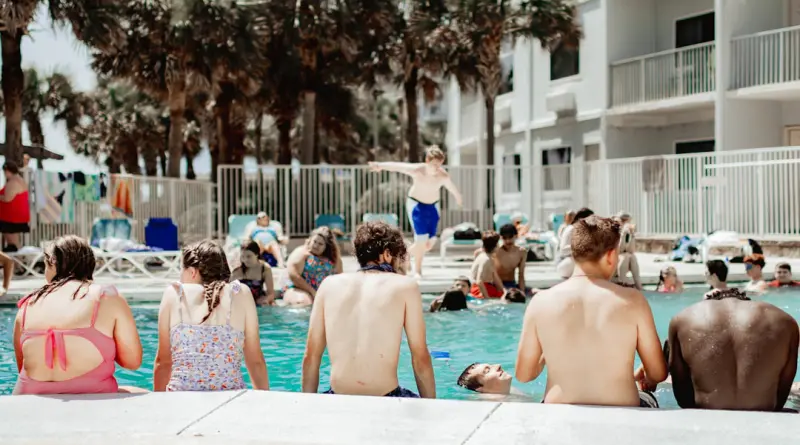 A group of people sitting next to a swimming pool
