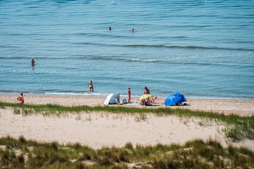 Sunny beach scene with people swimming and relaxing